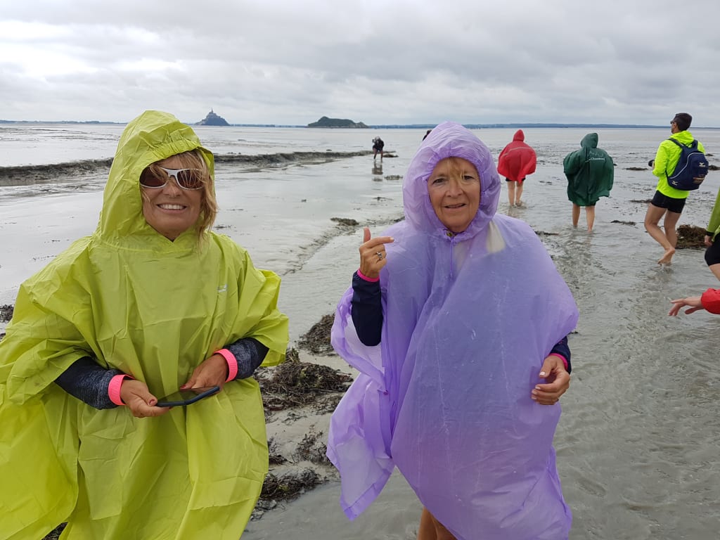 Gruppo di turisti con giacche colorate durante una visita guidata lungo la costa della Normandia, Francia.